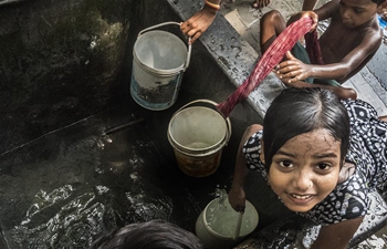 Indian children cool themselves in hot summer afternoon